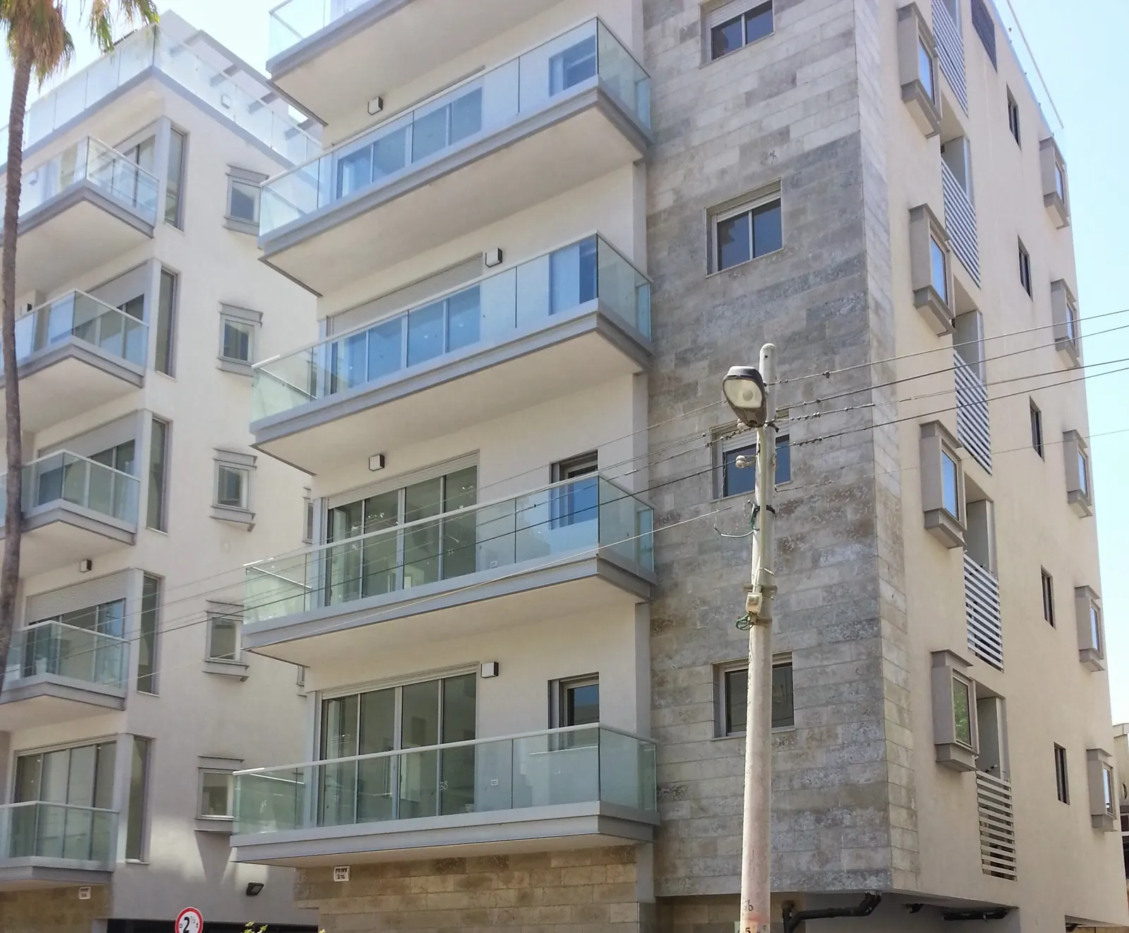 בניין מגורים גמור בפרויקט תאומי גרשון בתל אביב - מרפסות זיזיות עם מעקות זכוכית וחיפוי אבן