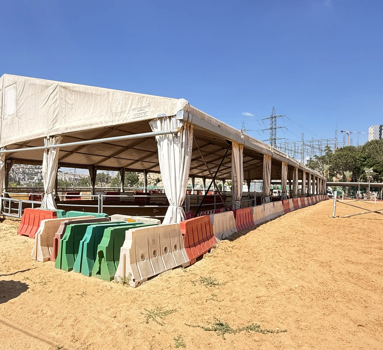 אוהל קירוי מודולרי במפתח רחב עם וילונות קשורים מעל מגרש רכיבה טיפולית בחוות אמיר, ירושלים