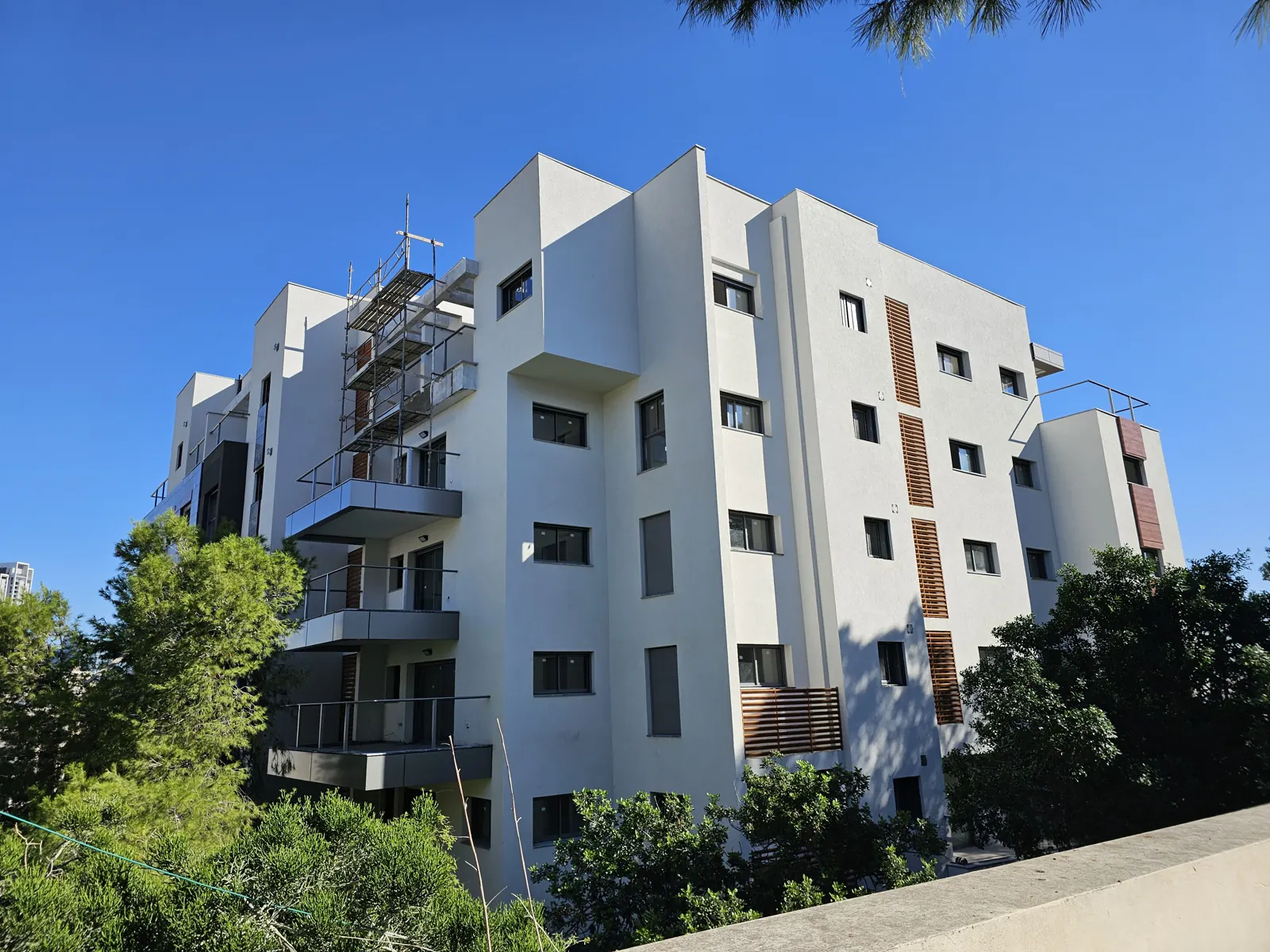 בניין המגורים החדש בנורדאו 18 ברמת גן - חזית לבנה, מרפסות זיזיות וחיפוי דמוי עץ